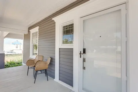 Front porch entry with glass-panel door, leaded-glass window and wicker chairs at Classen Manor, Oklahoma City