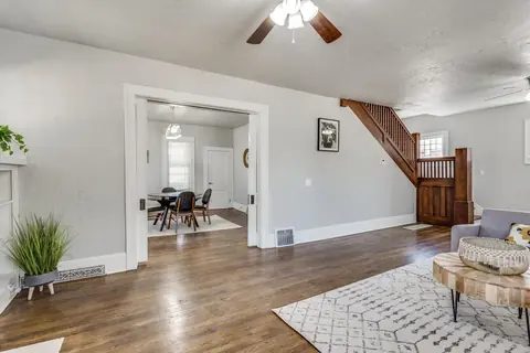 Wide pocket-door opening to the dining room beside the original wood staircase and banister at Classen Manor, Oklahoma City