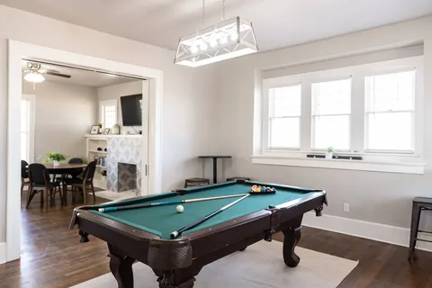 Game room at Classen Manor — pool table opening to the dining room of the century-old home