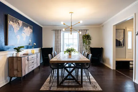Dining room at Quail Creek Manor: world-map art on a navy accent wall over a wood sideboard