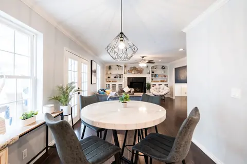 Breakfast nook with round marble-top table opening to the fireplace living room at Quail Creek Manor