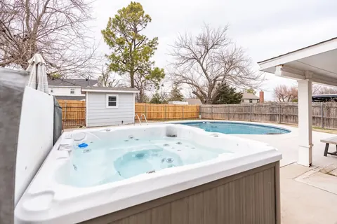 Bubbling private swim spa beside the backyard pool at Quail Creek Manor