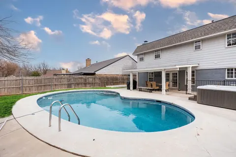 Backyard pool with ladder, covered patio and hot tub at Quail Creek Manor