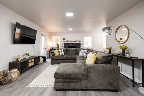 The Village Manor living room: oversized gray sectional, arc lamp and round mirror
